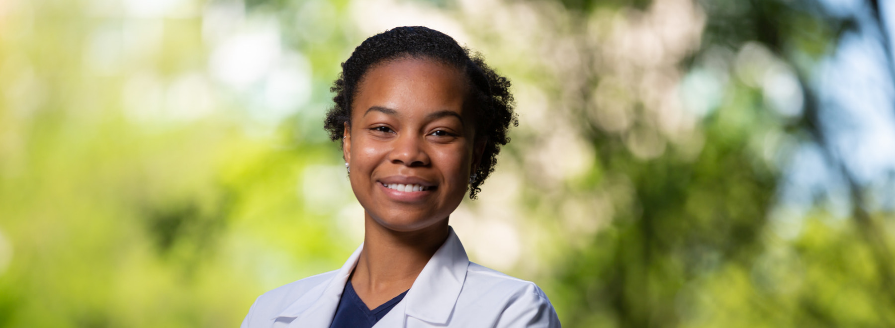 Female dental hygiene student poses in school of medicine courtyard.